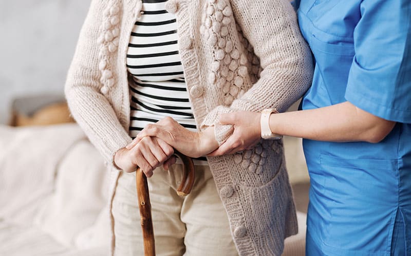Retirement home nurse helping patient in senior living community
